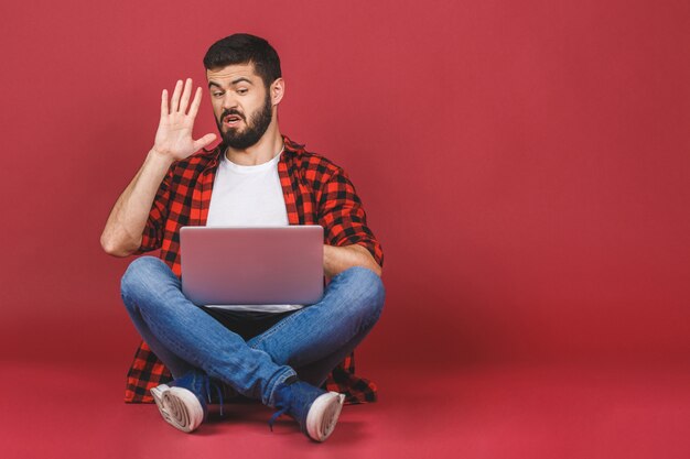 Modello di giovane studente maschio che si siede sul pavimento