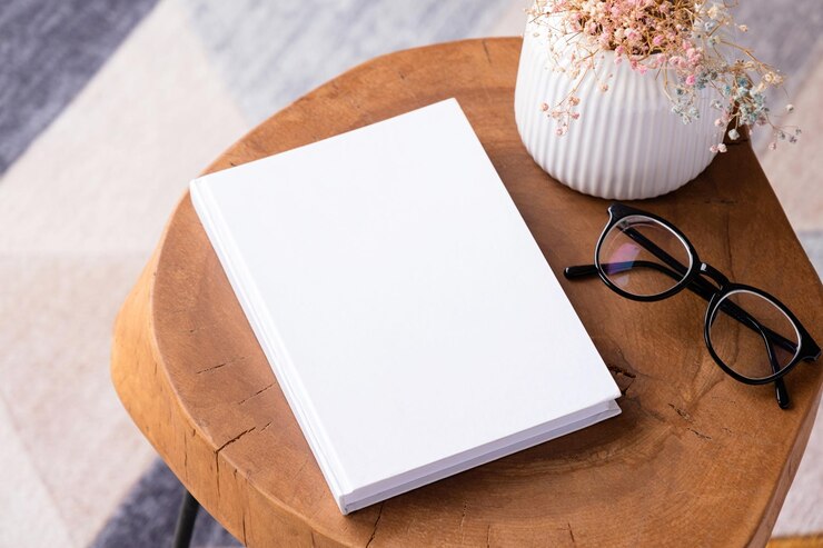modello di libro vuoto su tavolo da caffè con fiori da decorazione e tappeto colorato