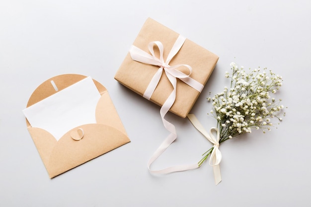Modello di matrimonio con lista di carta bianca e fiori gipsofila su tavolo colorato vista piana piana carte di auguri vuote e buste bellissimo disegno floreale stile piana