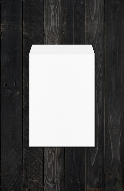 Modello di mockup grande A4 enveloppe bianco isolato su fondo di legno nero