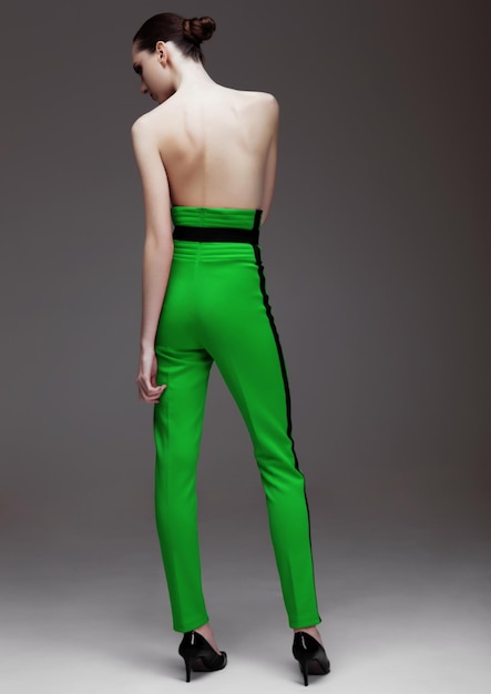 Modello di moda che indossa pantaloni verdi e camicia bianca