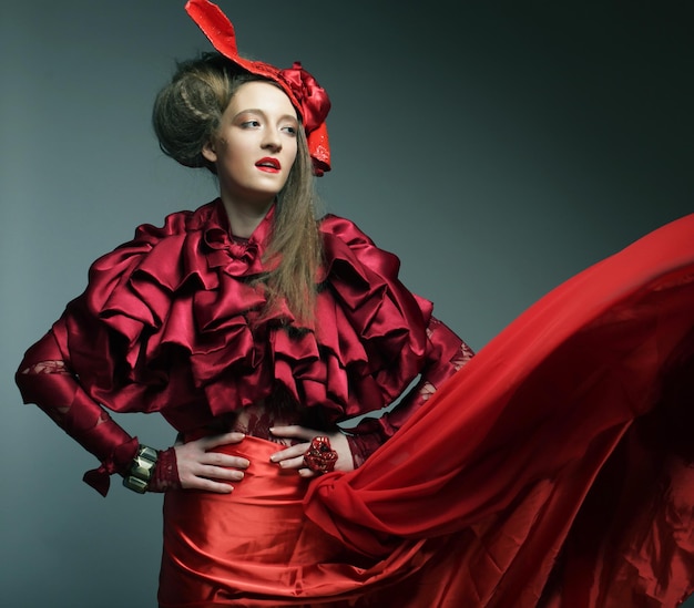 Modello di moda glamour in costume rosso eleganza con cappello rosso Studio shot