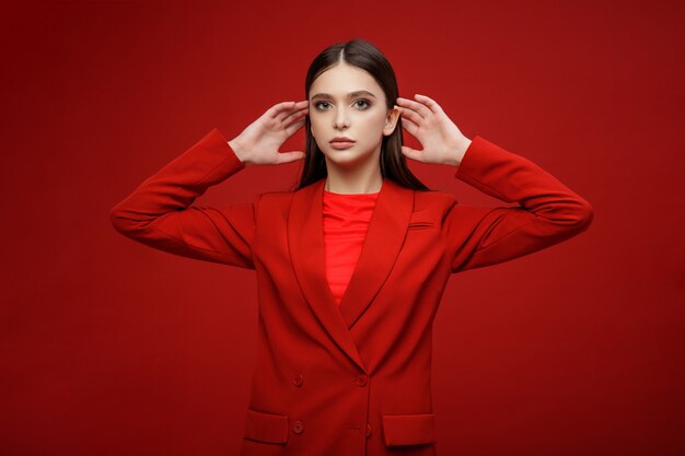 Modello di moda in gonna giacca abito rosso Bella giovane donna Sfondo rosso