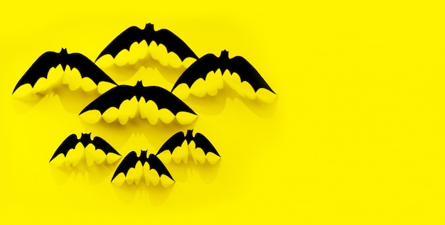 Modello di pipistrello di carta minimalista con ombra che cade sul giallo.