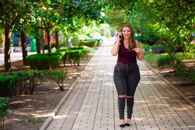 Modello di ragazza bionda plus nel parco.