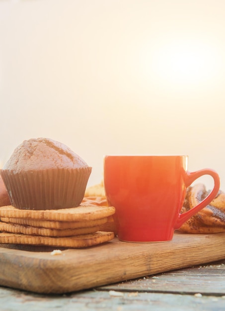 Modello di tazza di caffè rosso spazio vuoto con muffin al cioccolato in caffè della città all'aperto