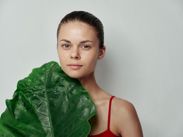 Modello di toelettatura delle foglie di palma verde della pelle pulita della giovane donna