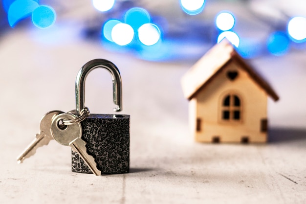 Modello di una casa di legno con una serratura e chiavi e bokeh