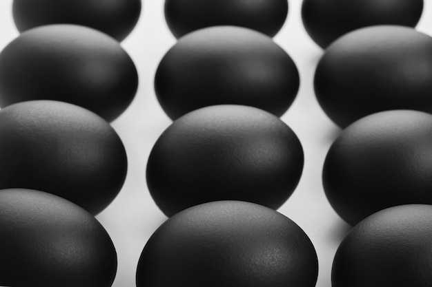 Modello di uova di Pasqua nere su sfondo bianco. Concetto minimalista di Pasqua