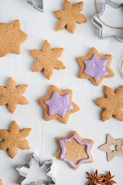 Modello fatto di biscotti di panpepato salati dolci con glassa viola sulla tavola di legno bianca