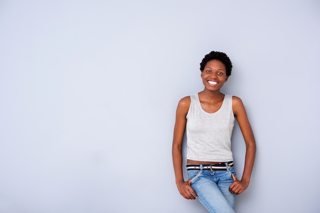 Modello femminile afroamericano fresco che posa sulla parete grigia