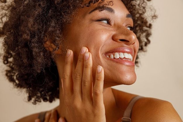 Modello femminile alla moda che posa contro il muro beige