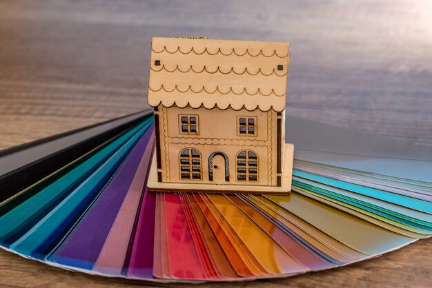 Modello giocattolo della casa in legno sul campione di colore