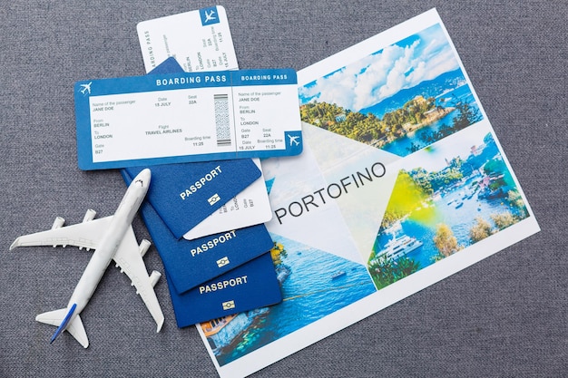 Modello in bianco bianco dell'aereo passeggeri sui passaporti con carta d'imbarco su fondo di legno rustico blu