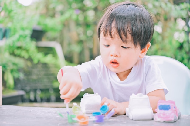 Modello in gesso fai-da-te Pittura con vernici colorate,Bambino che dipinge il modello in gesso,Concetto creativo. Colori ad acqua.