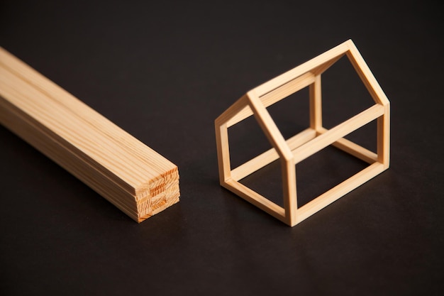 Modello in miniatura di casa con struttura in legno con pila di assi di legno