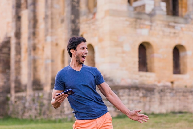 Modello indiano uomo maturo che balla Bollywood con la musica dello smartphone ritmo di viaggio in Europa casuale
