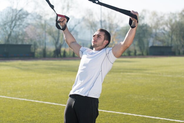 Modello muscolare che fa esercizi pesanti per il trapezio