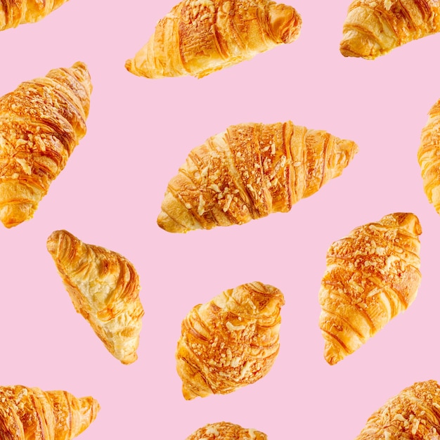 Modello senza cuciture a base di croissant freschi con formaggio isolato su sfondo rosa