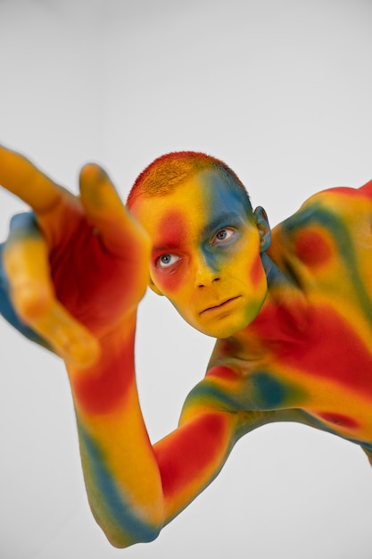 Modello uomo in posa con body painting colorato