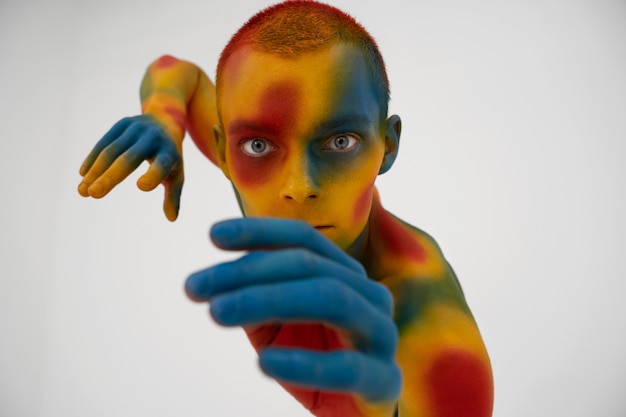 Modello uomo in posa con body painting colorato