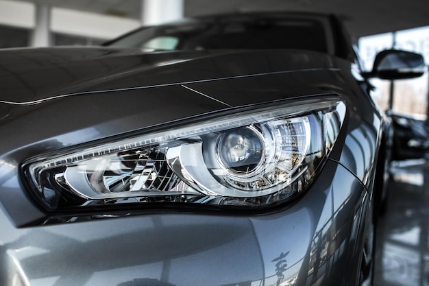 Modern luxury car close-up Concept di costosa auto sportiva Lampada anteriore di nuova auto spazio di copia Un'auto moderna ed elegante illuminata