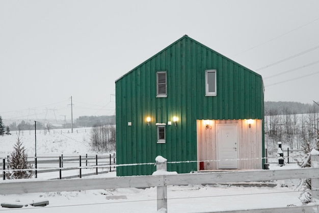 Moderna casa in legno in stile scandinavo con giorno invernale di colore diverso nel villaggio