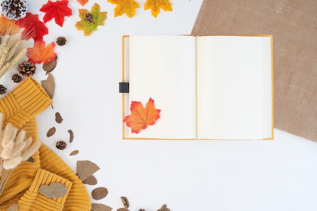 Moderna scrivania da ufficio con tazza da caffè quaderno giallo foglie d'autunno rosso su sfondo bianco con spazio di copia posto per il tuo testo tavolo da lavoro con forniture per ufficio concetto accogliente accogliente autunno stagionale