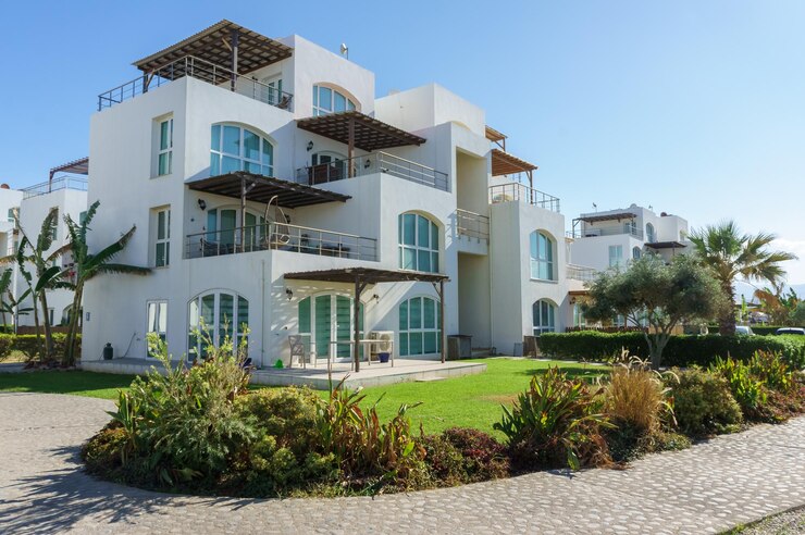 Foto moderna villa bianca con lussureggianti giardini in una zona costiera soleggiata durante il giorno
