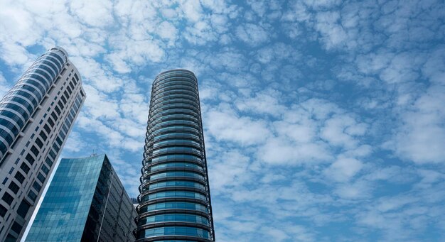 Moderni edifici a torre o grattacieli nel quartiere finanziario con nuvole in una giornata di sole