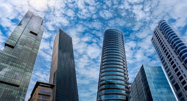 Moderni edifici a torre o grattacieli nel quartiere finanziario con nuvole in una giornata di sole