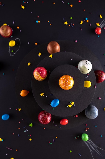 Moderno dipinto a mano con caramelle al cioccolato di diversi colori come uno spazio e pianeti Concetto di pubblicità del prodotto