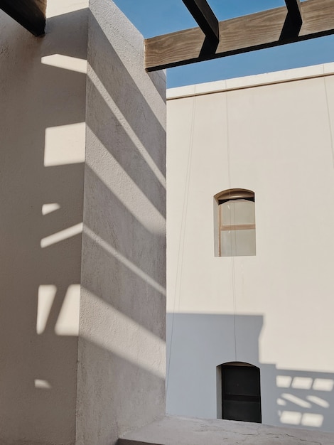 Moderno edificio in stile orientale con pareti beige, finestre e ombre della luce solare su rotaia