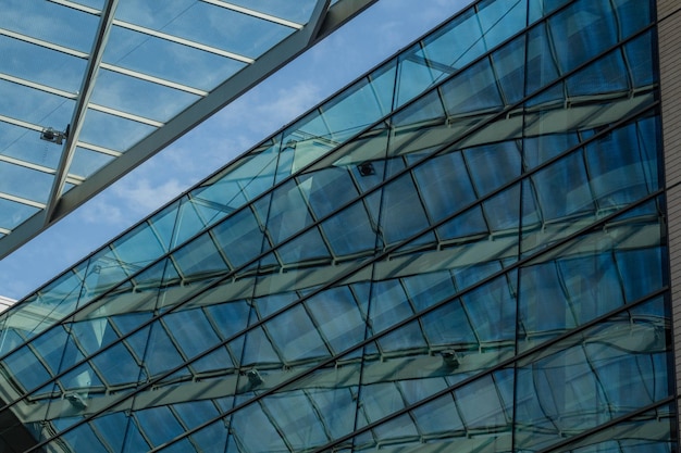 Moderno edificio per uffici commerciali con facciata in vetro su uno sfondo di cielo blu