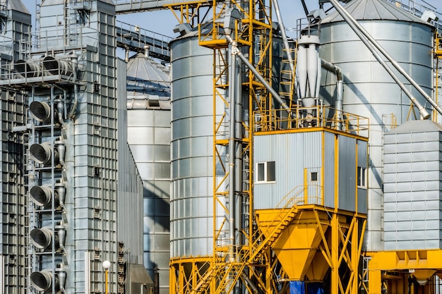 Moderno elevatore per granaio Silos d'argento su impianto di agroprocessing e produzione per la lavorazione, asciugatura, pulitura e stoccaggio di prodotti agricoli, farina, cereali e linea di pulizia dei semi di grano