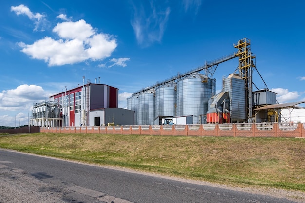 Moderno elevatore per granaio Silos d'argento su impianto di agroprocessing e produzione per la lavorazione, essiccazione, pulizia e stoccaggio di prodotti agricoli farina cereali e grano