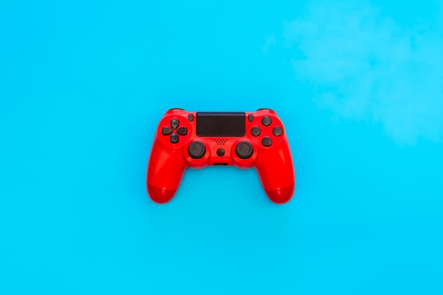 Moderno gamepad rosso su sfondo blu controller di gioco per videogiochi spazio di copia piatto