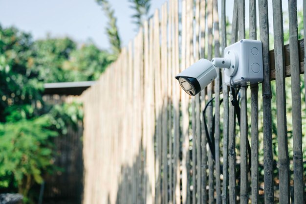 Moderno sistema di sicurezza CCTV sullo sfondo di una parete di legno in giardino Protezione antifurto con telecamera intelligente