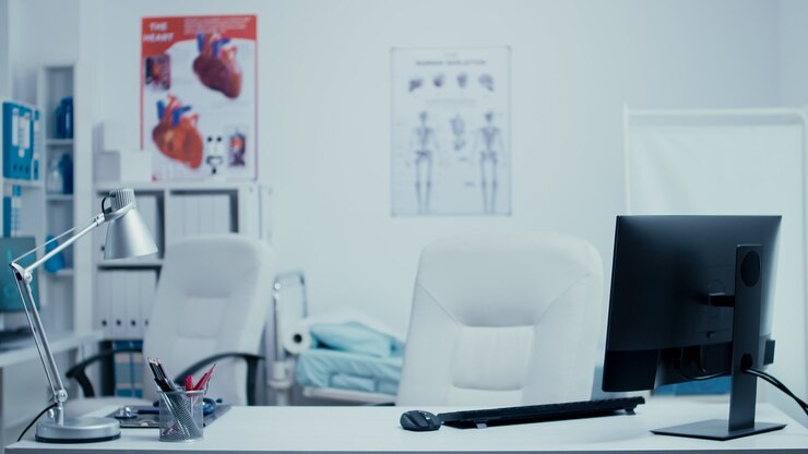 Foto moderno ufficio di consulenza medica senza nessuno al suo interno. stanza clinica privata dell'ospedale con pareti di vetro, computer sull'armadietto dei medicinali pulito del sistema sanitario della reception. apparecchiature per il trattamento e professio
