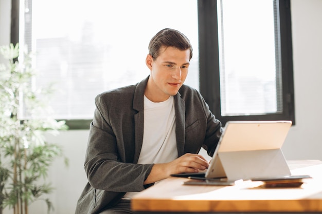 Moderno uomo sorridente impiegato che lavora in ufficio al computer