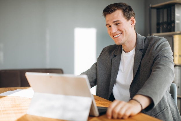 Moderno uomo sorridente impiegato che lavora in ufficio al computer