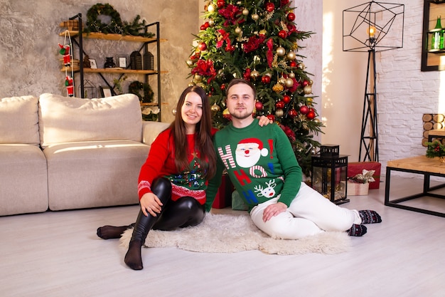 Moglie e marito vicino all'albero di Natale a casa