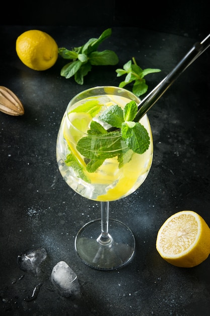 Mojito cocktail o limonata con menta in vetro nero. Avvicinamento. Bevanda estiva