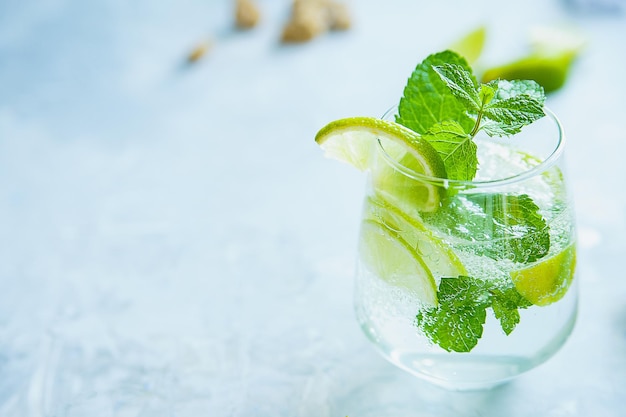 Mojito con ingredienti zucchero di canna tritato lime e menta su fondo chiaro