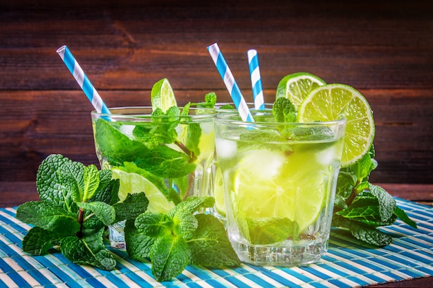 Mojito con menta e lime in un bicchiere e una brocca