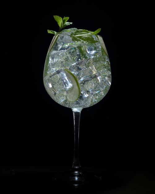 Mojito di lusso in un bicchiere grande su sfondo nero un cocktail alcolico in un ristorante chic