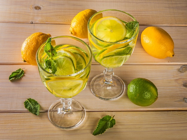 Mojito rinfrescante del cocktail di estate con calce e la menta sulla tavola di legno.