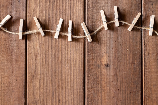 Mollette di legno e spago di iuta su fondo di legno marrone