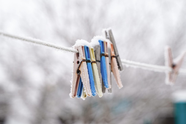 Mollette di plastica e di legno su una corda da bucato in inverno nella neve all'aperto