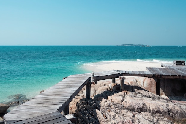 Molo in legno sulla spiaggia di sabbia bianca.